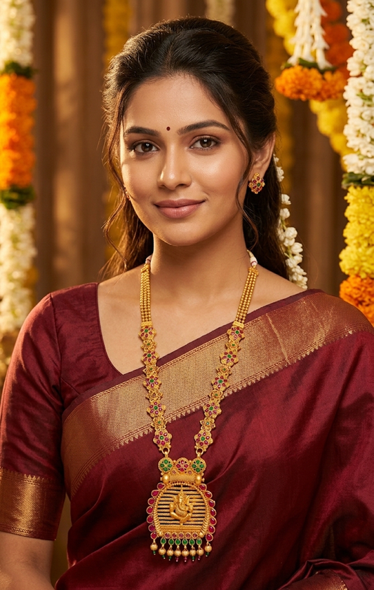 Traditional Gold Temple Jewelry Set: Long Haram Necklace and Matching Jhumka Earrings with Red Stone Accents and Pearl Drops